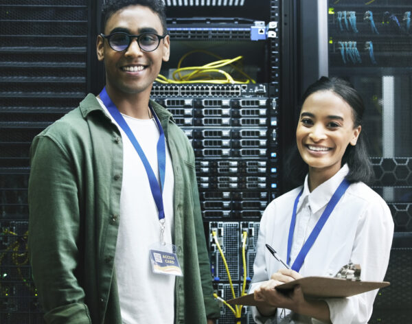 No virus, no problem. Shot of two technicians working together in a server room